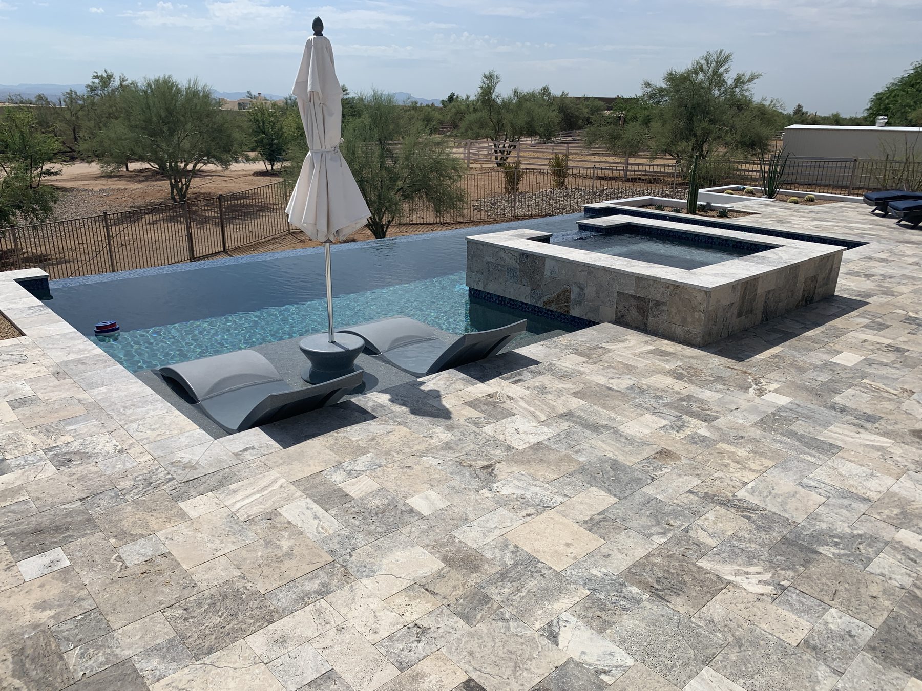 Shallow shelf loungers beside raised spa — Standard Pools project