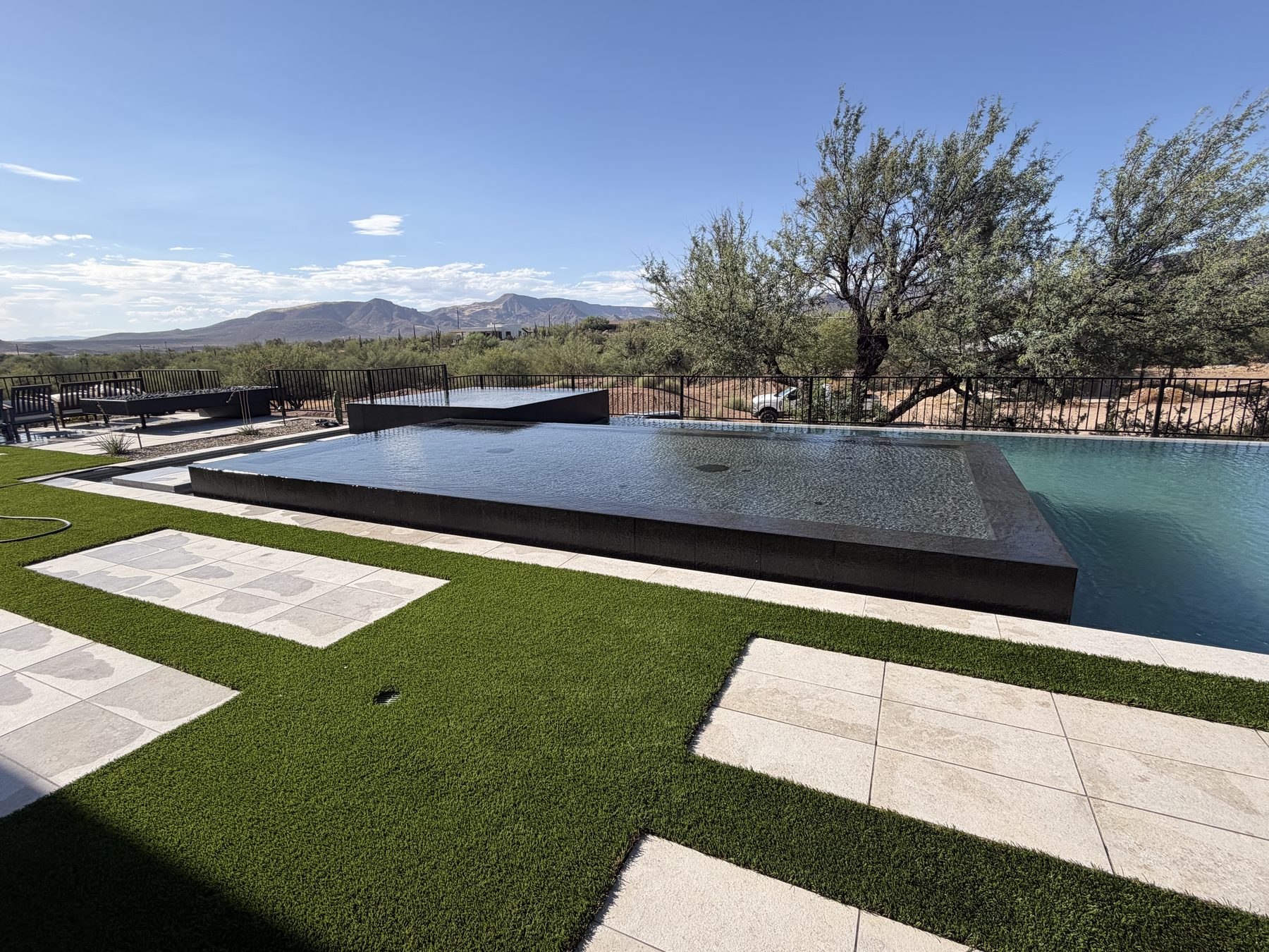 Paver walkway pads and turf leading to a modern pool — Standard Pools project